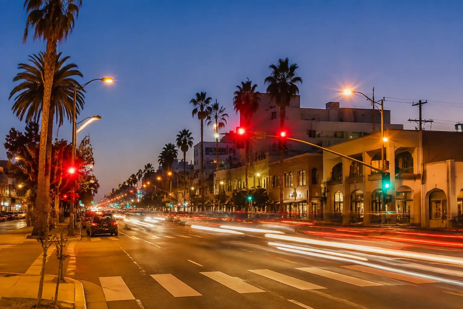 Sunset Boulevard in Los Feliz at dusk with traffic lights and cars moving along the commercial corridor