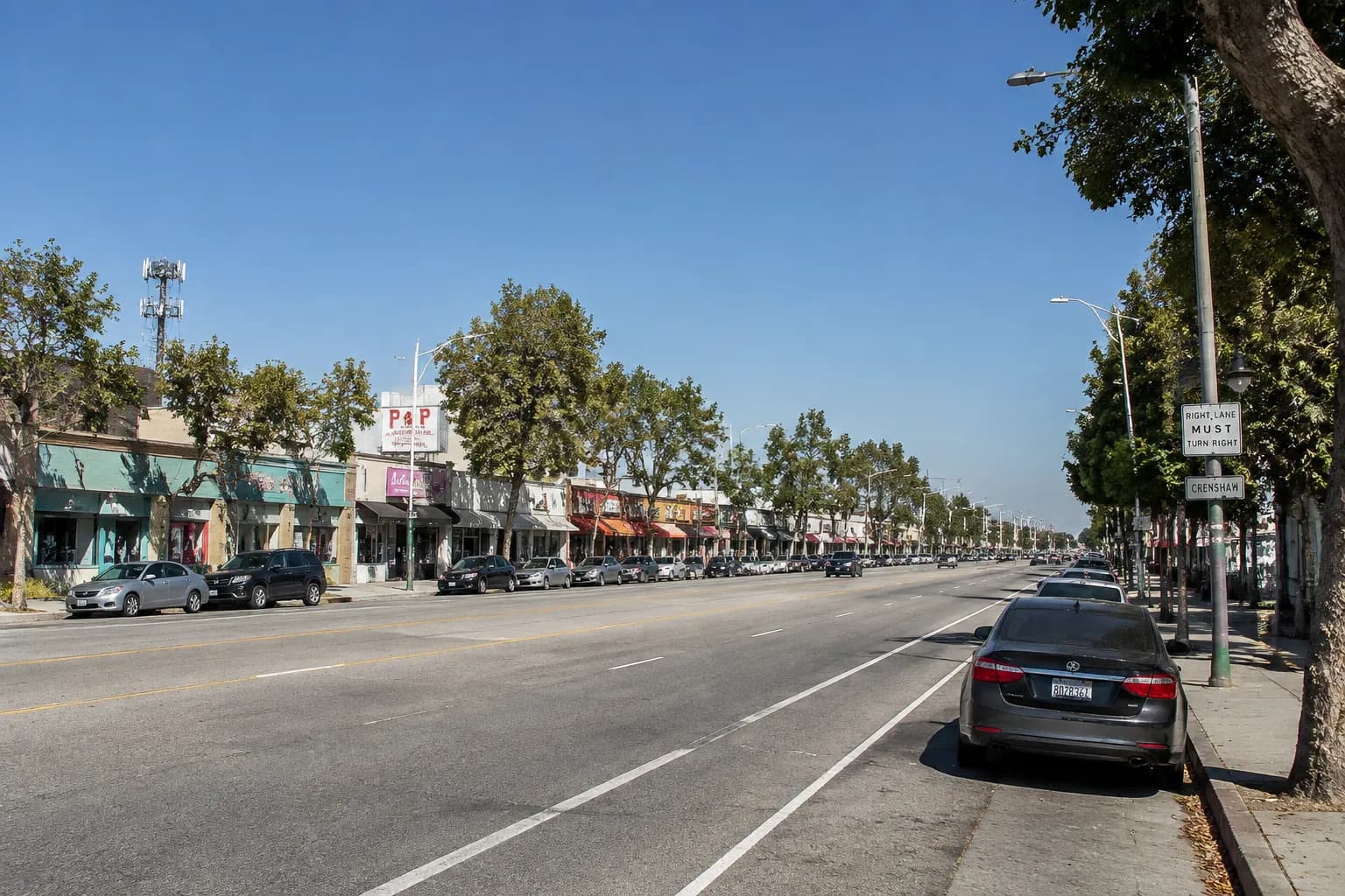 Crenshaw Boulevard in Los Angeles on a weekend morning showing storefronts and parked cars