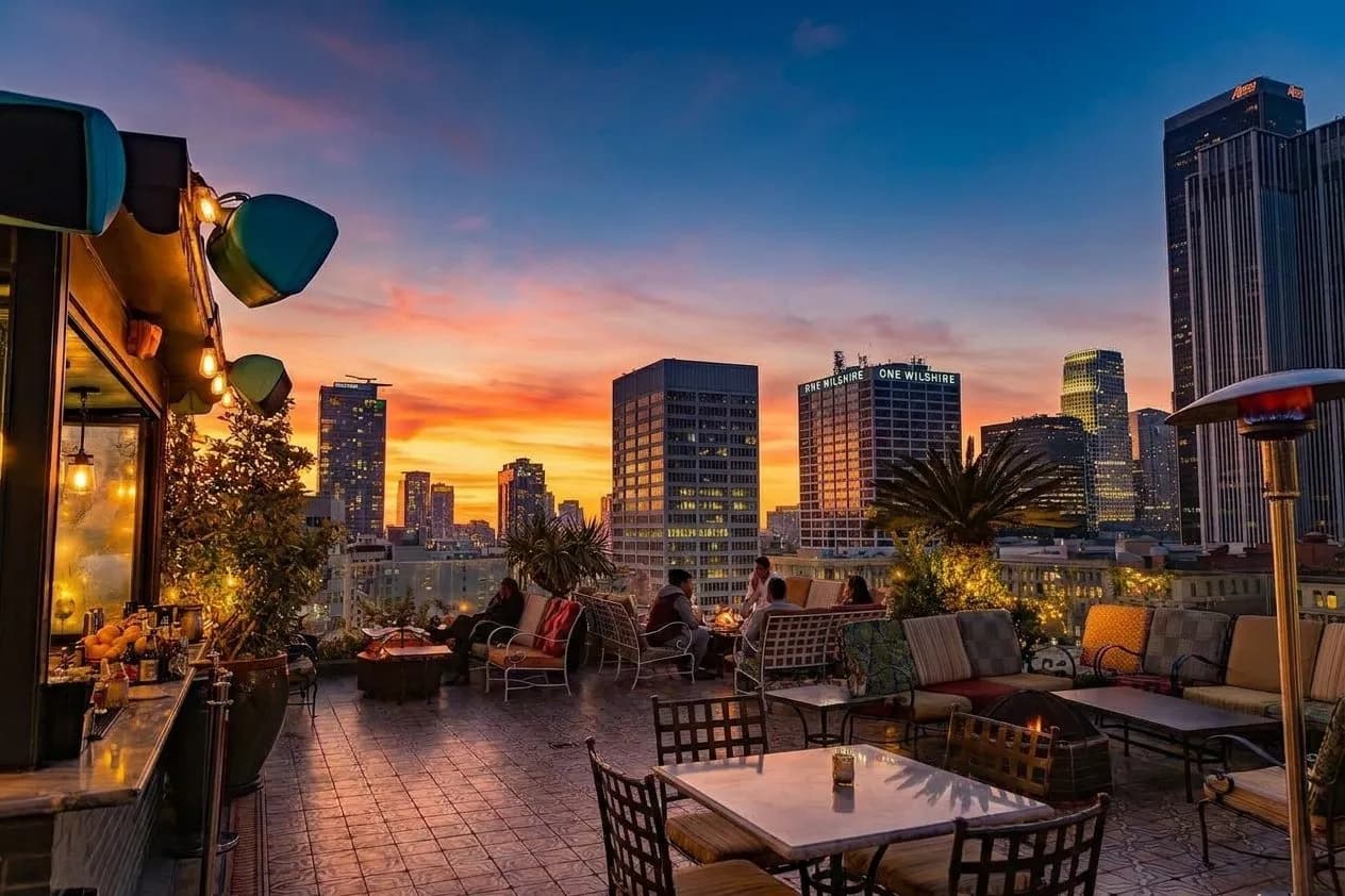 Los Angeles rooftop bar with skyline glow at sunset