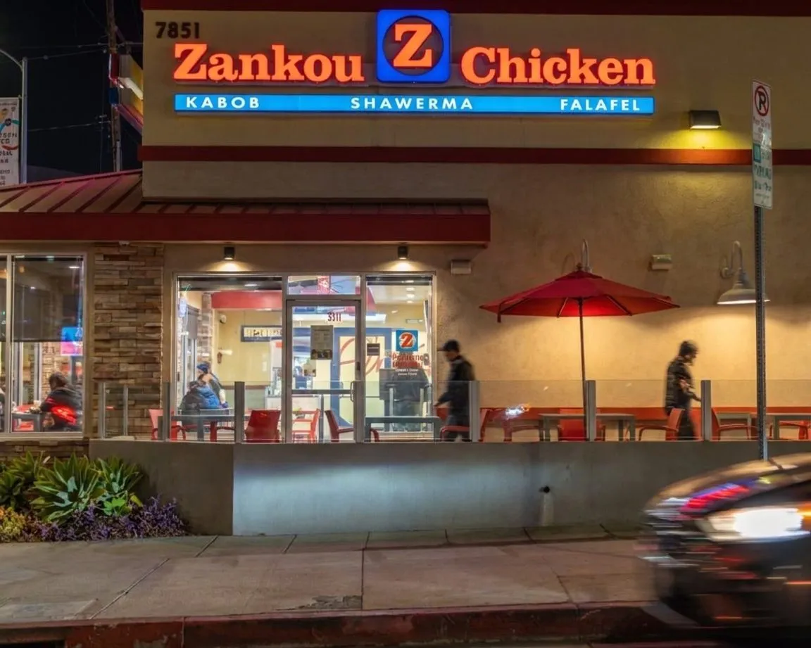 A late-night chicken spot with cars pulling up for takeout