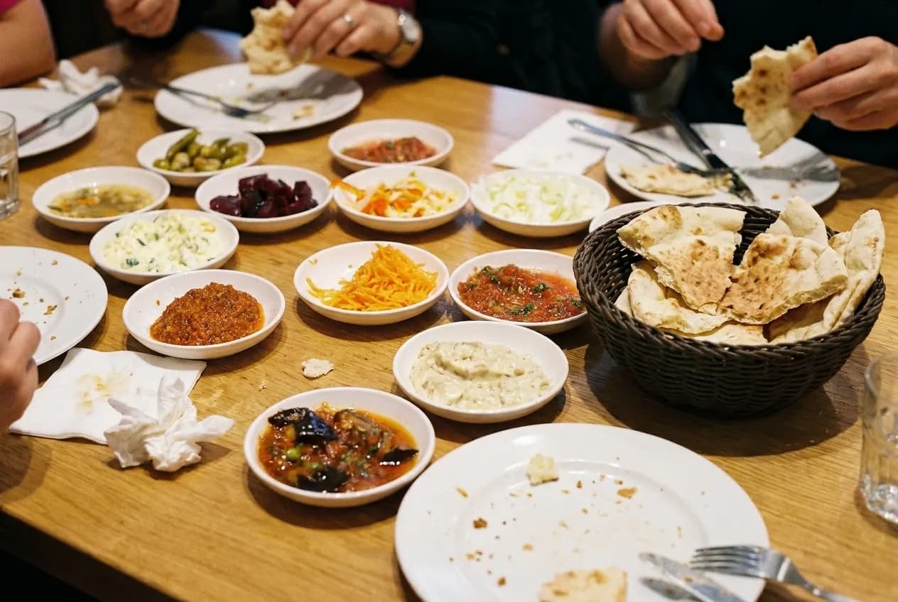 A table of small plates and flatbread photographed from above mid-meal