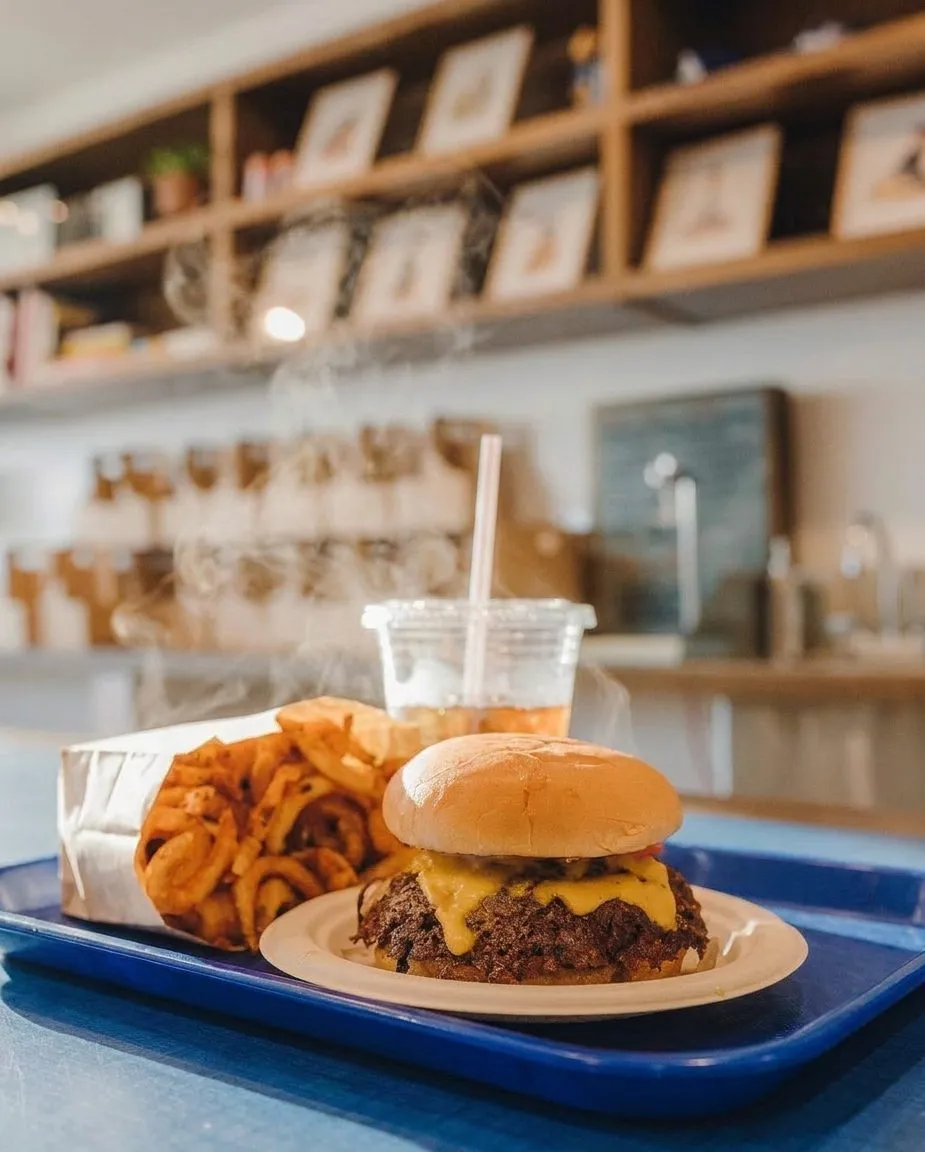 A smashed cheeseburger with crisp edges on a paper-lined tray