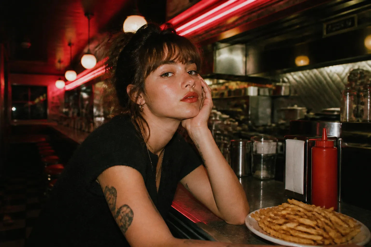 Neon-lit diner counter late at night with a plate of fries