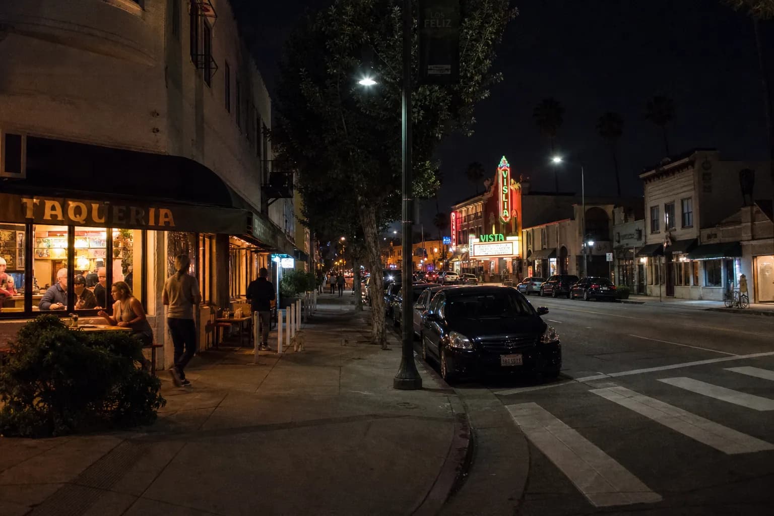 A glowing Los Feliz taco storefront on a quiet night street corner