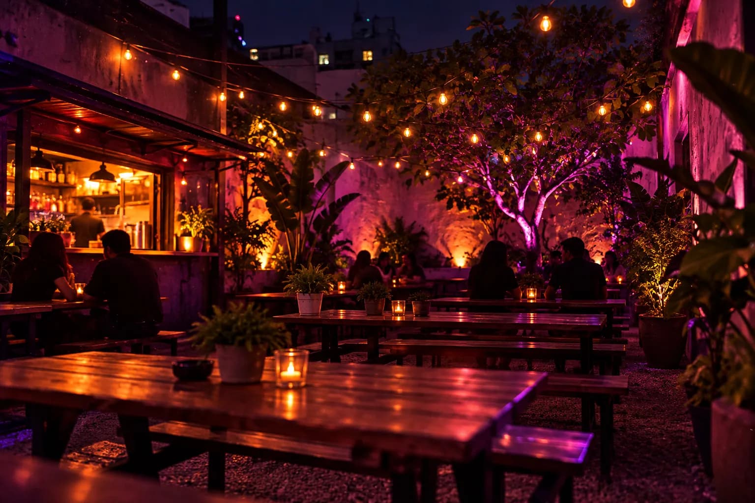 A string-lit back patio with picnic tables at a bar