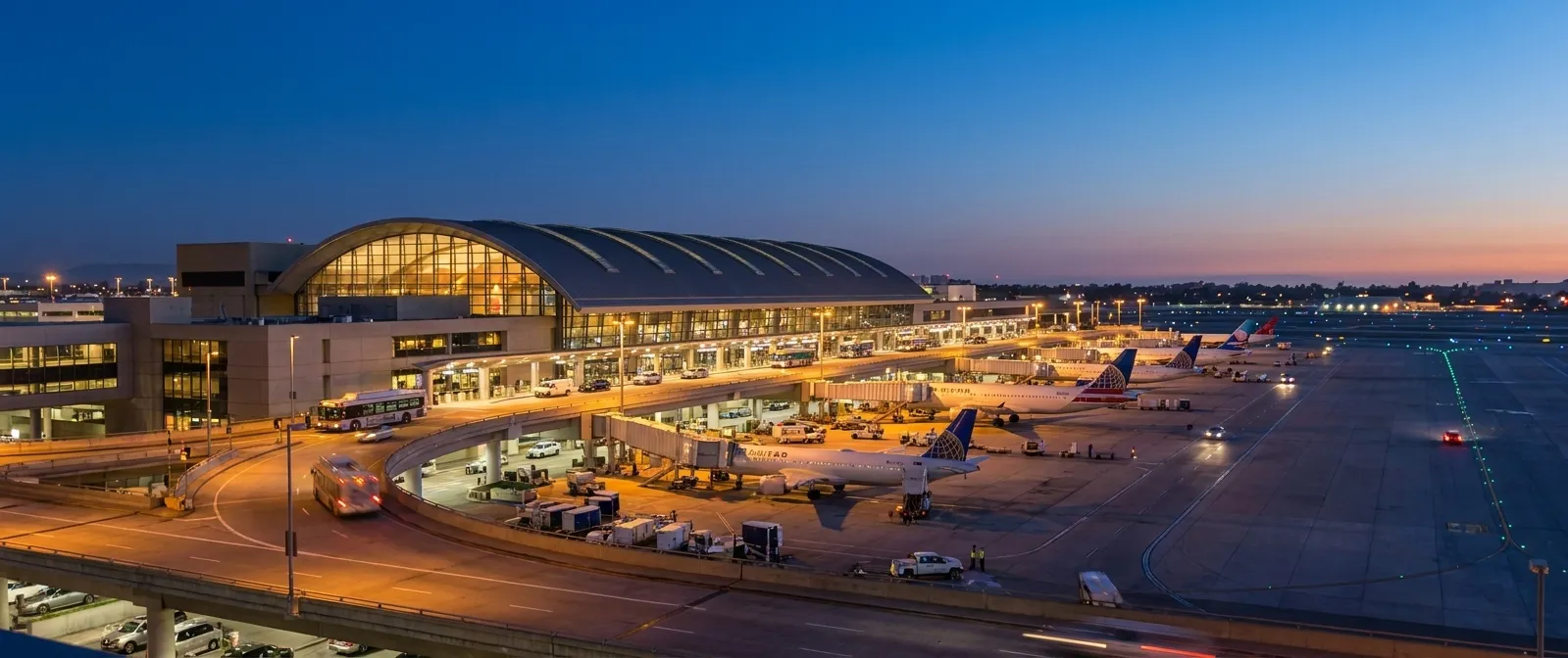 Tom Bradley International Terminal at LAX illuminated at night with aircraft on the ramp