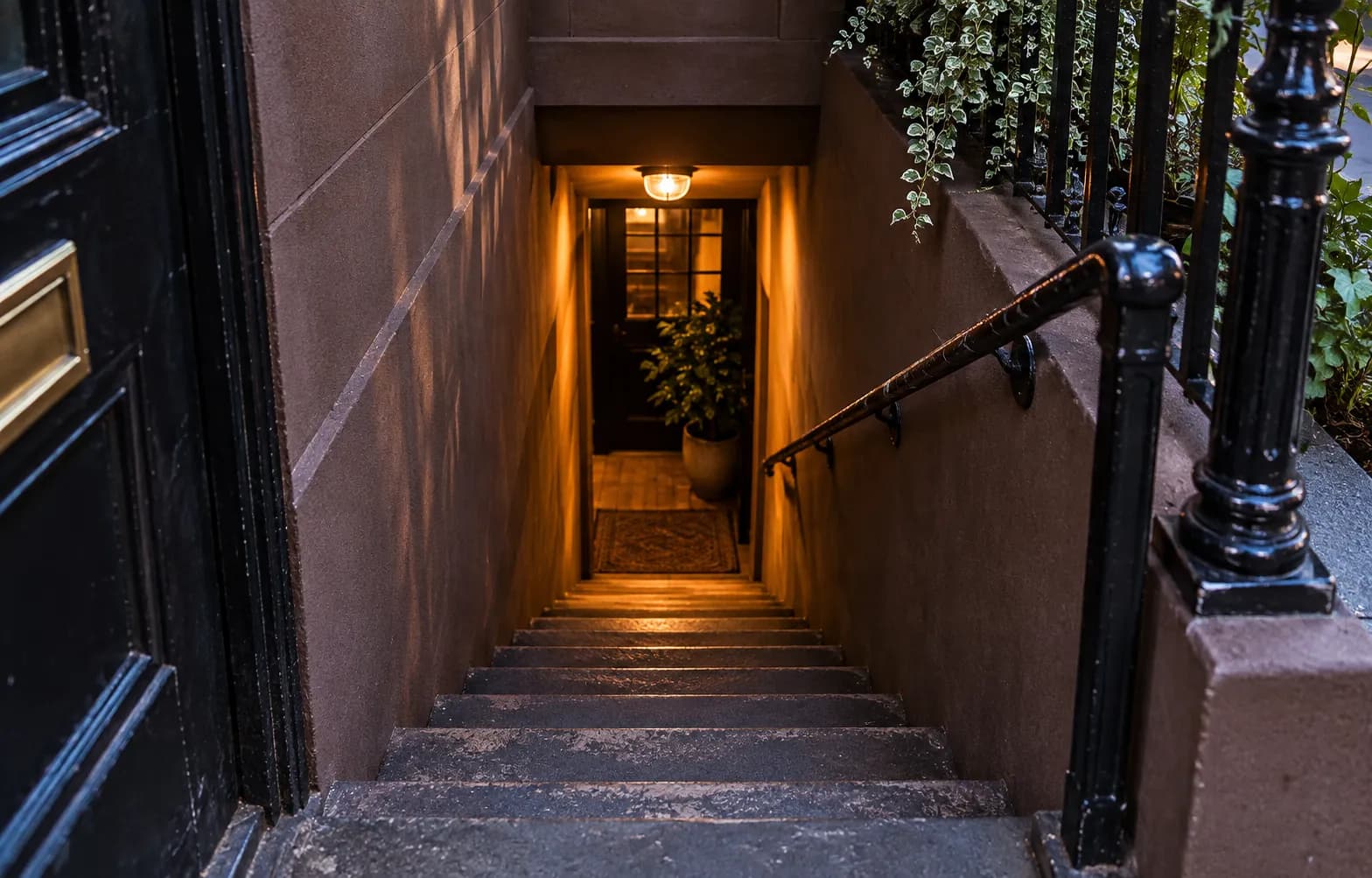 A steep narrow staircase descending from a street door to a basement club