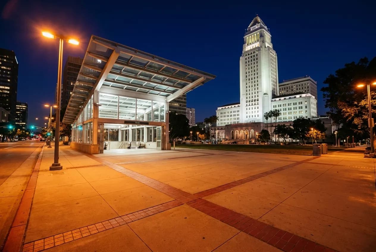 Metro station entrance in downtown Los Angeles at night with streetlights and empty plaza