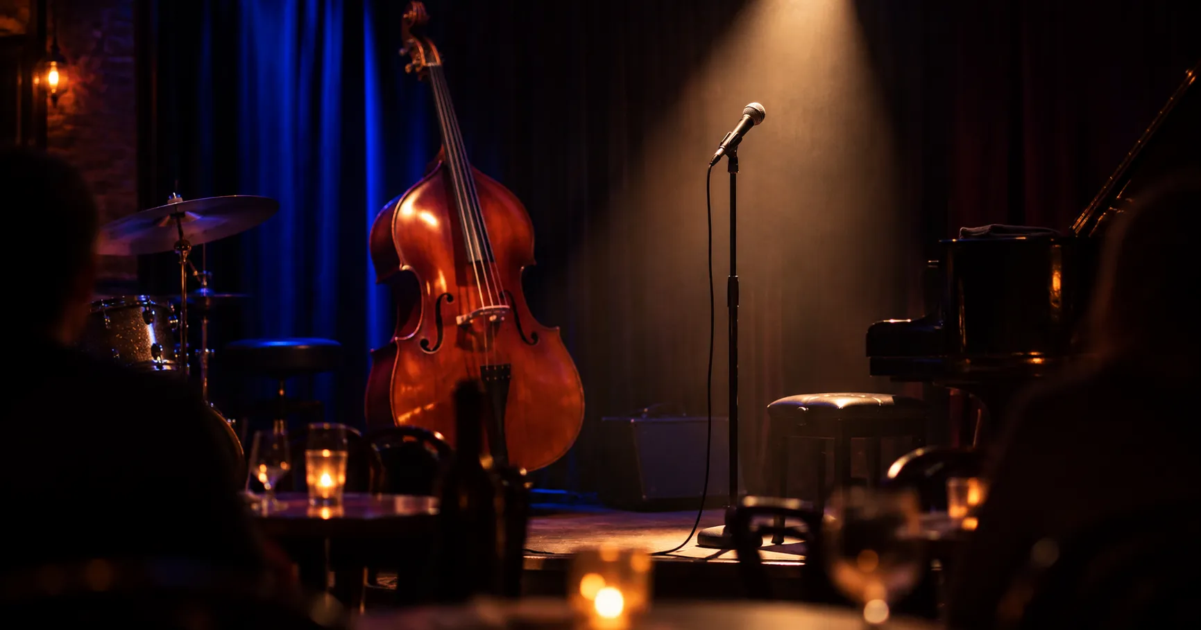 A double bass and a spotlit microphone on a small jazz club stage