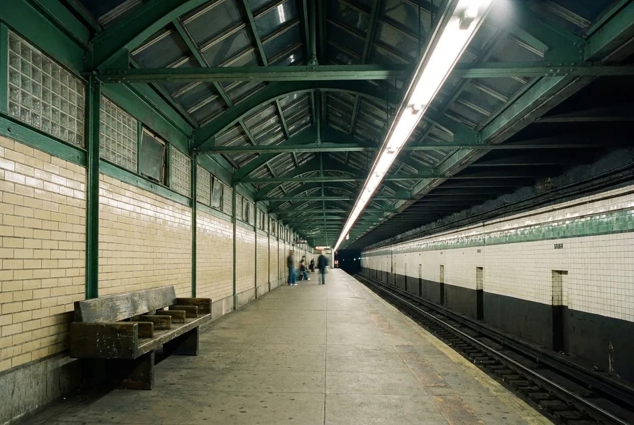 Late night subway platform with sparse crowd waiting for train