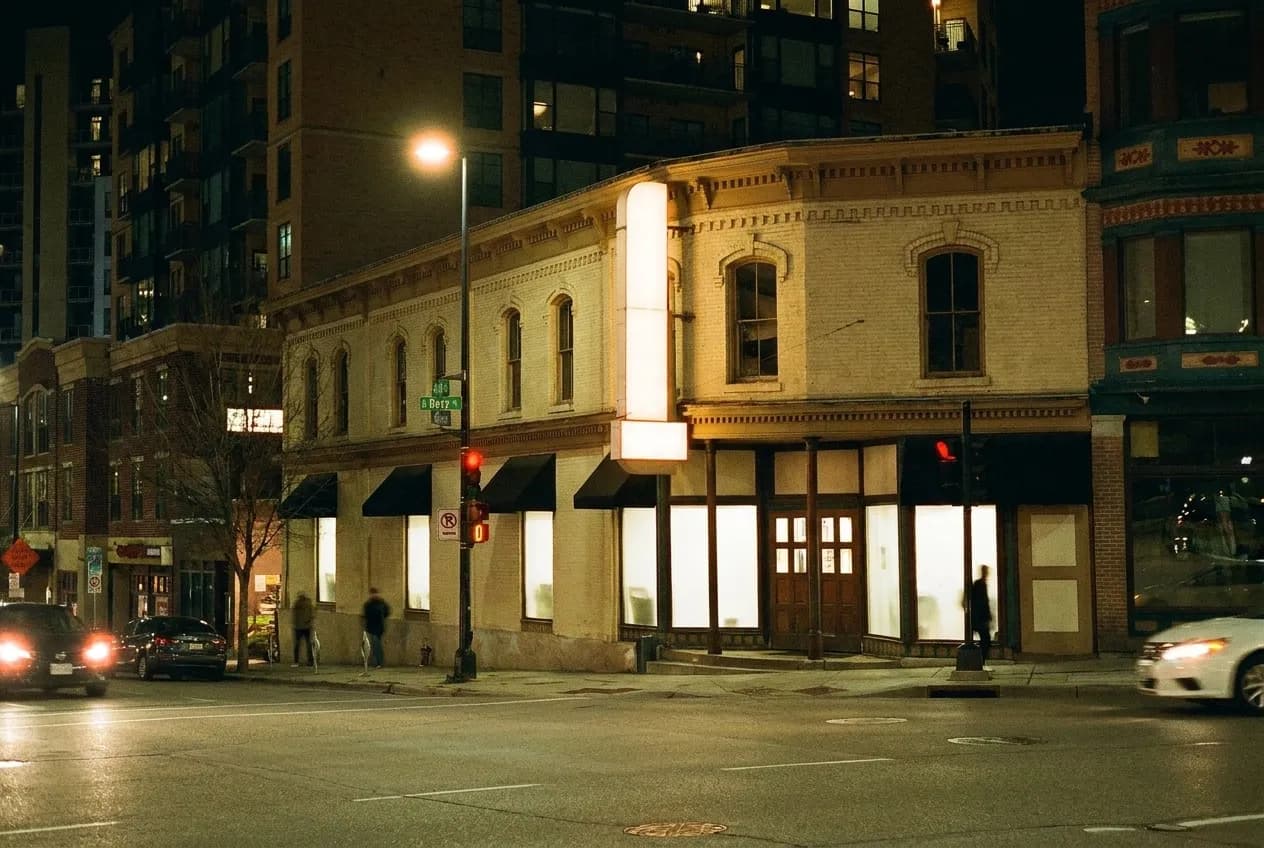 A low-slung bar building with a corner entrance on a wide boulevard at night in Los Angeles