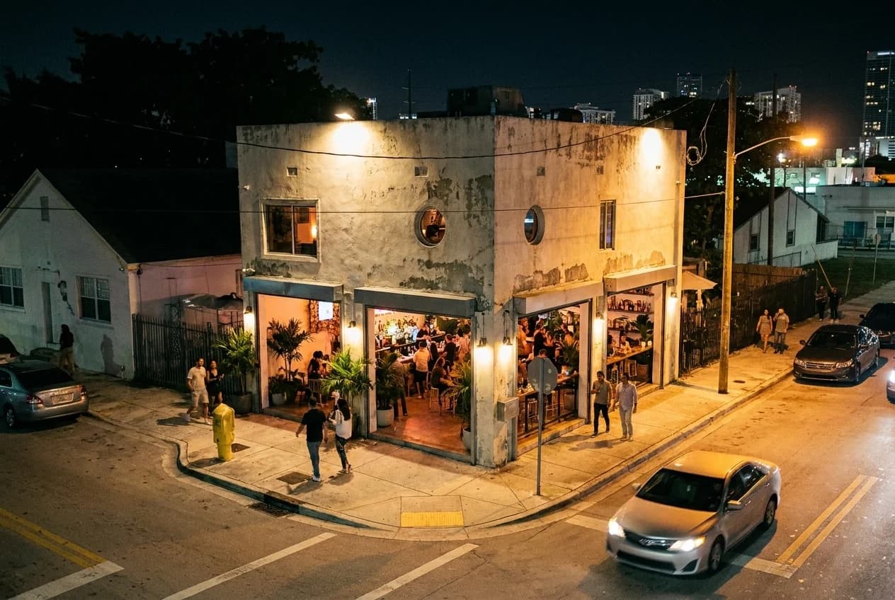Mayami Wynwood exterior on NW 23rd Street at night with open-air courtyard entrance and street lighting visible