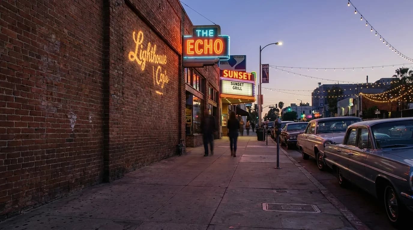 Sunset Boulevard in Echo Park at dusk with neon bar signs and parked cars along the curb