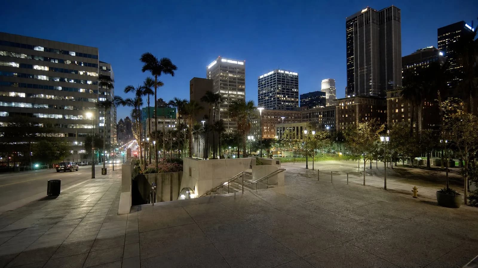 Pershing Square at blue hour with the Metro entrance, plaza paving, and nearby towers.