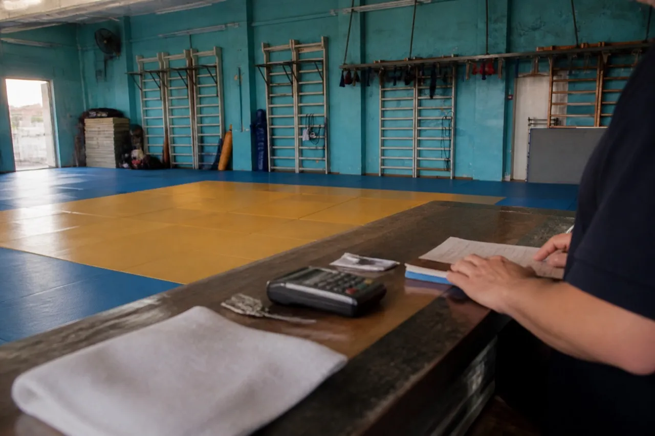 Training gym floor with mats and equipment along the wall