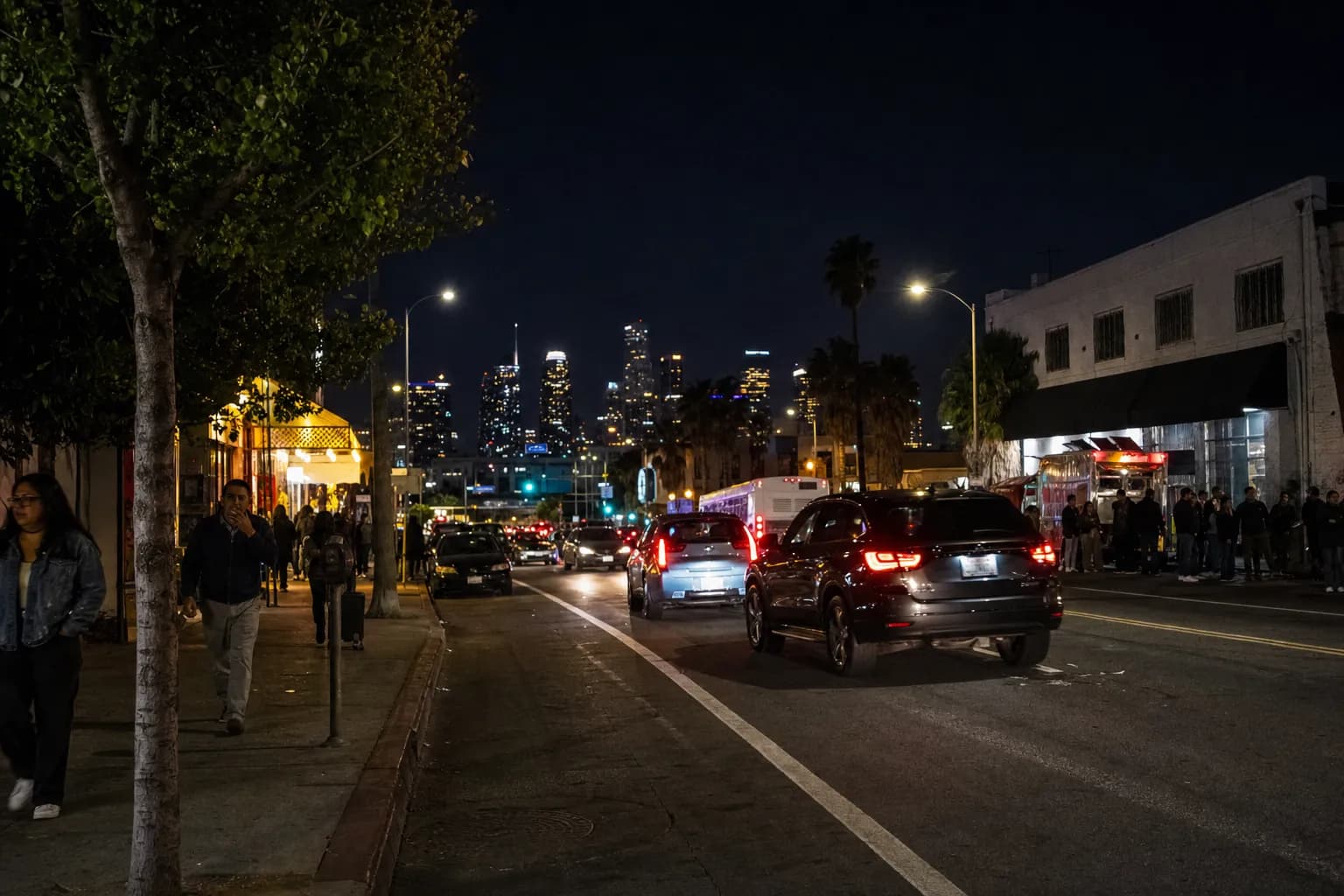 Late-night food street with pedestrians and buses near Westlake