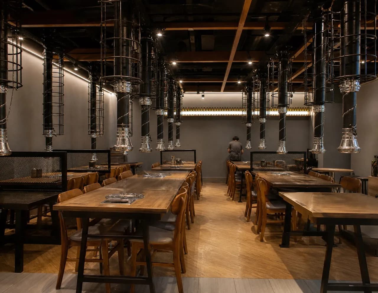 Korean restaurant dining room with extraction ducts over each table