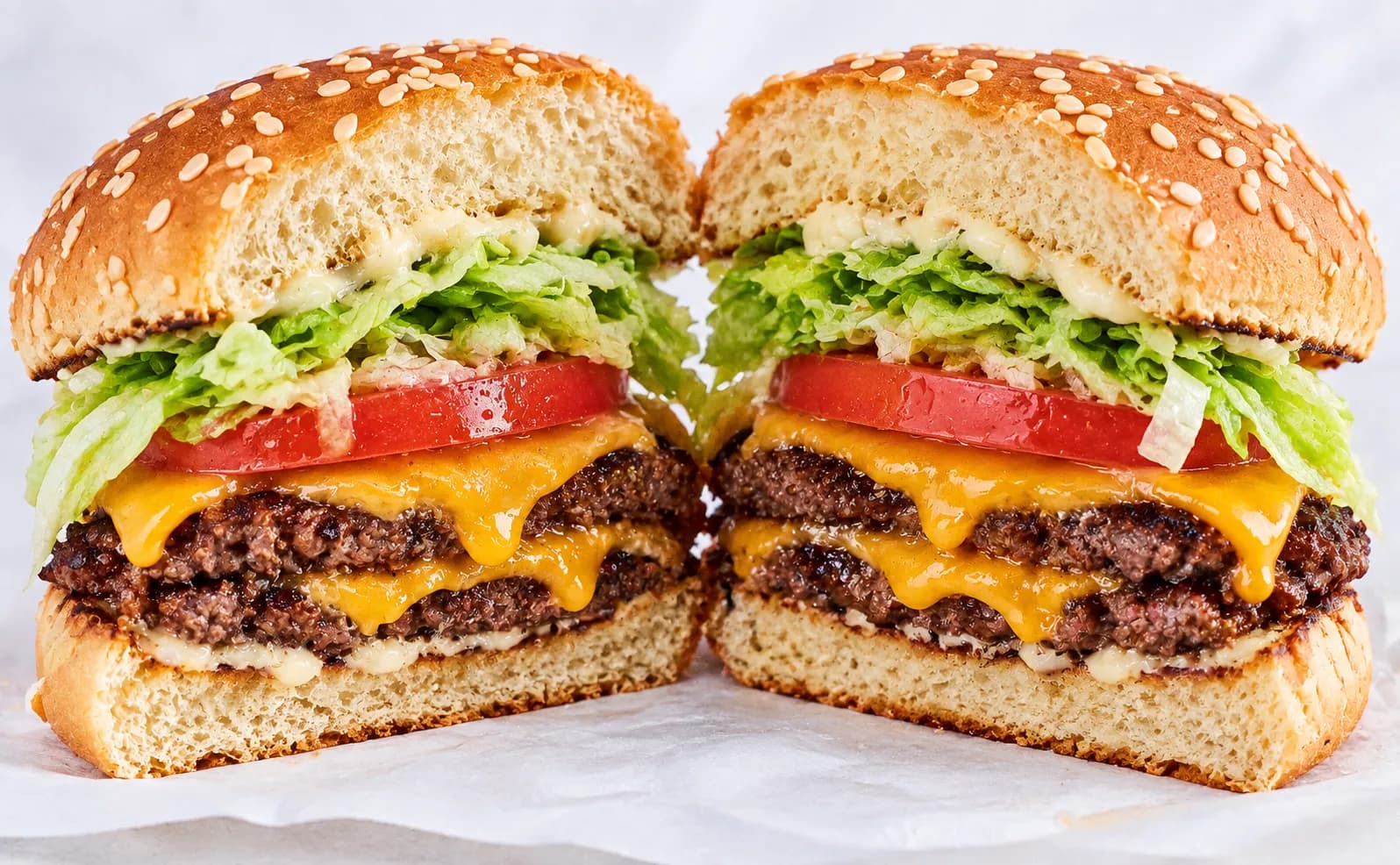 A double burger cut in half showing two patties and cheese