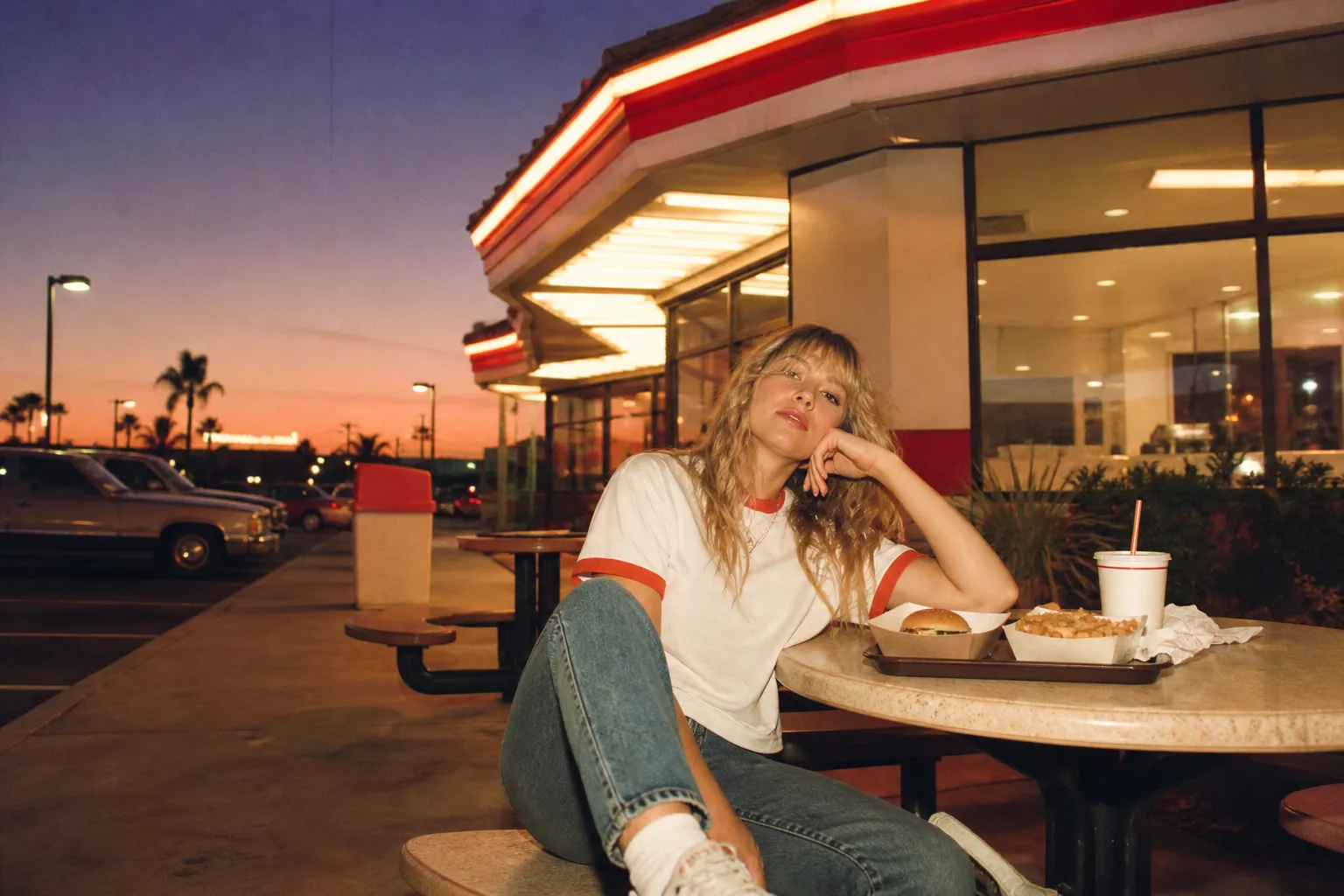 A fast food restaurant exterior lit warmly against a dusk sky