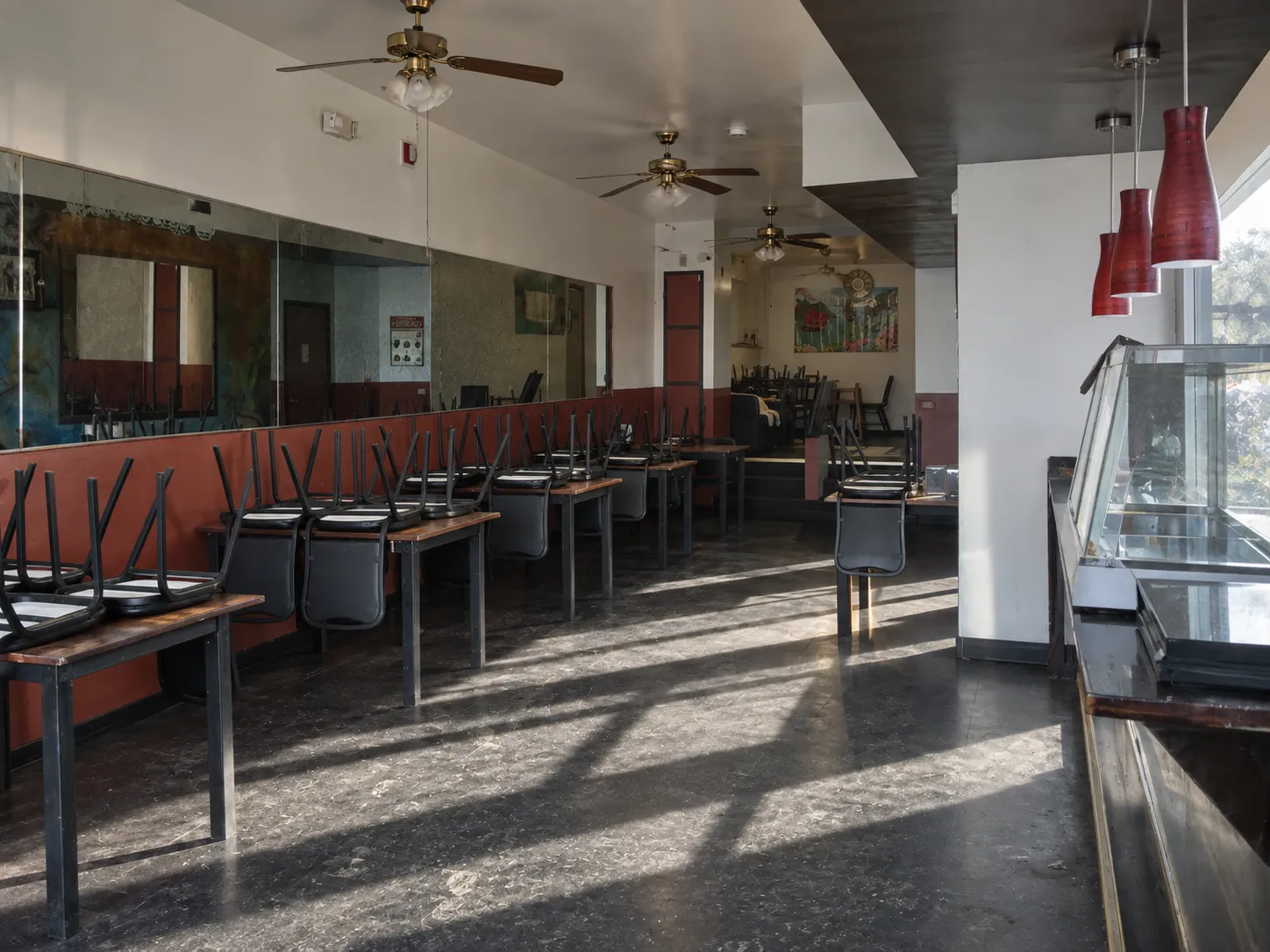 An empty restaurant dining room with bare tables and chairs turned up