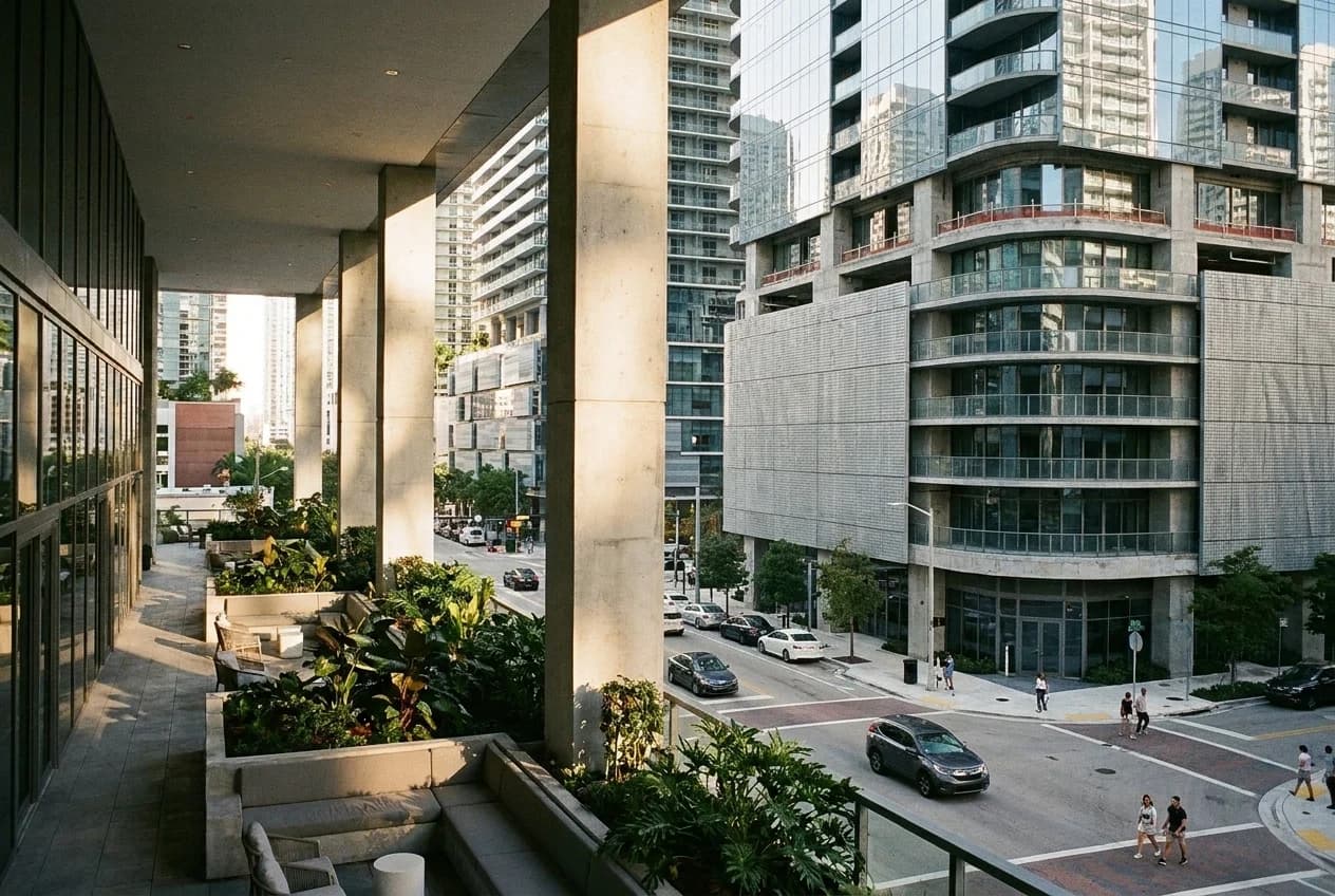 Brickell City Centre fourth-floor patio with concrete columns and planters, sunlight on glass tower facades
