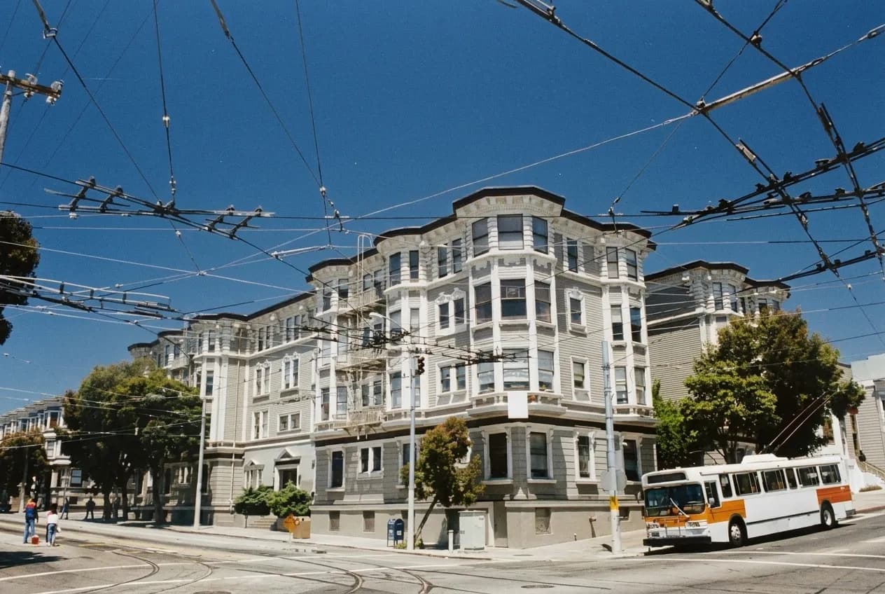 A quiet San Francisco corner with a small restaurant, street trees and a park beyond