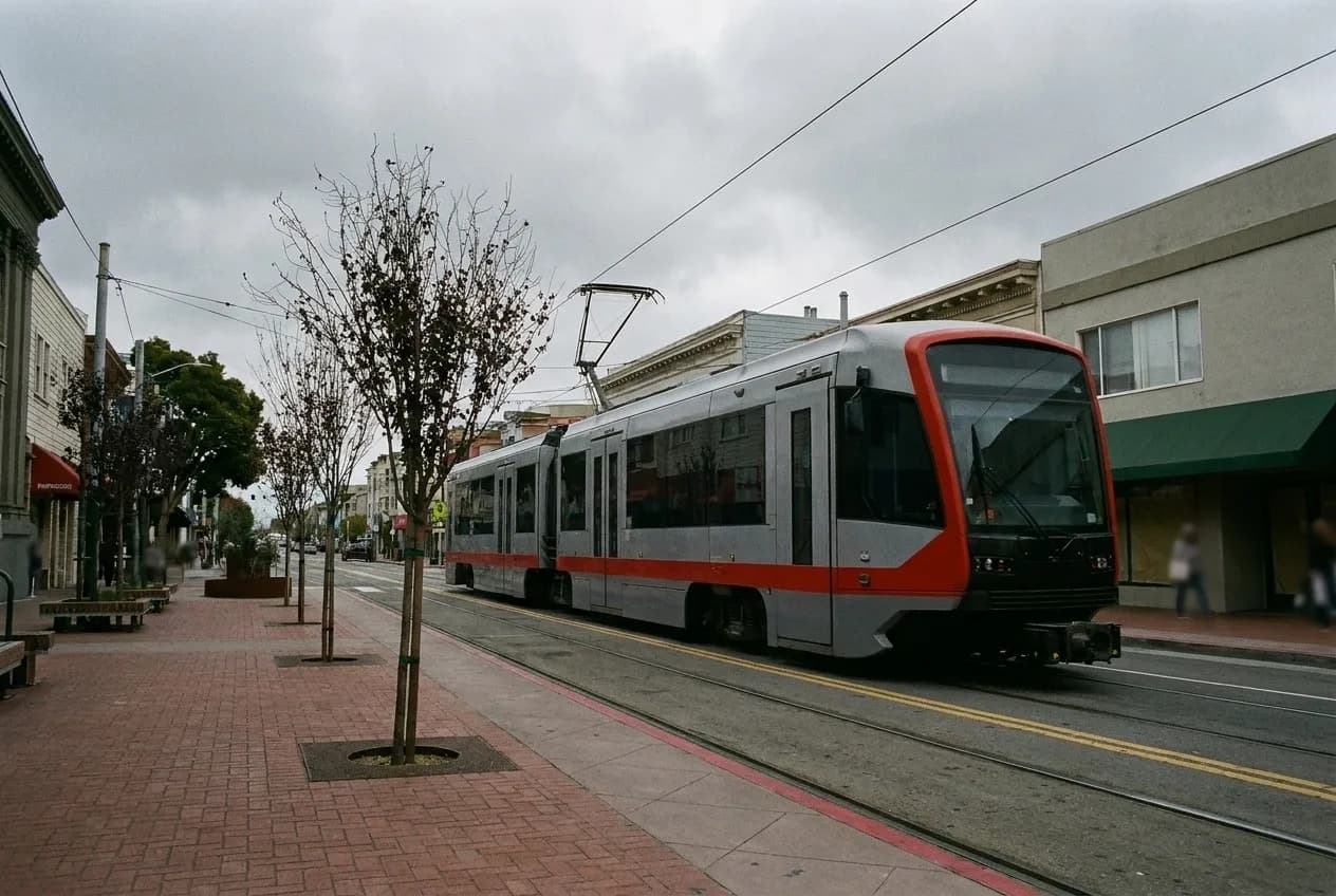 A long straight commercial street with awnings running east under grey sky in San Francisco