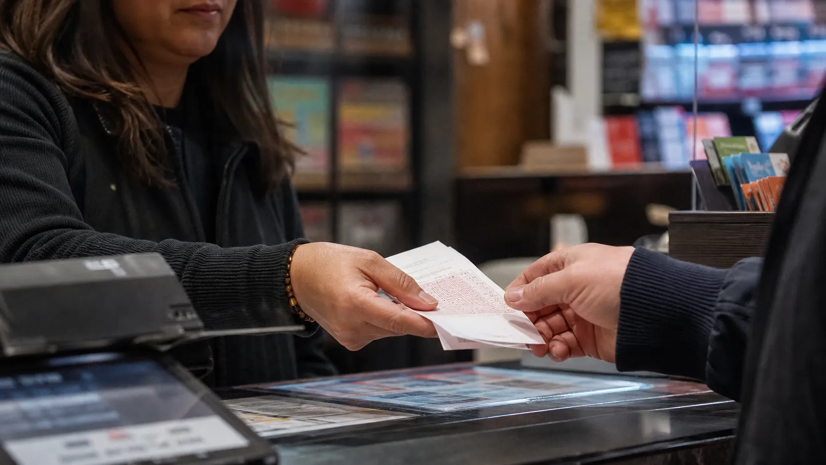 A customer receives a generic lottery ticket at a New York City store counter.