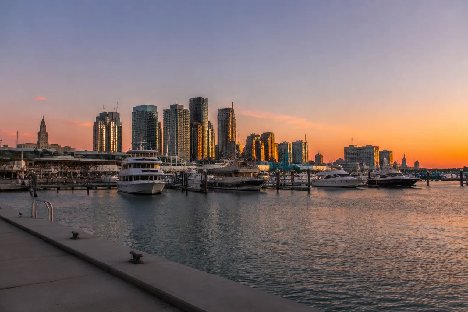 View of Bayside Marketplace marina docks at dusk with downtown Miami skyline in background