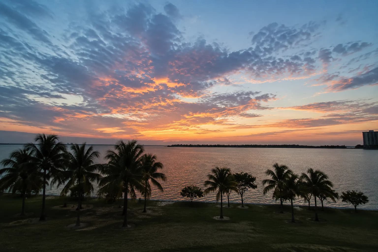 Evening view across Biscayne Bay from Bayfront Park with distant islands on horizon