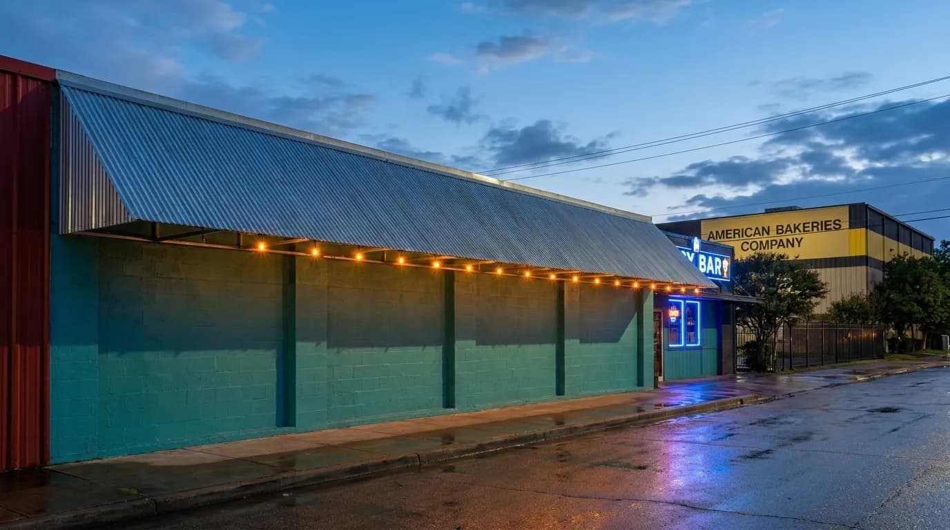 Covered storefront awning on a Wynwood street corner at dusk with glowing string lights
