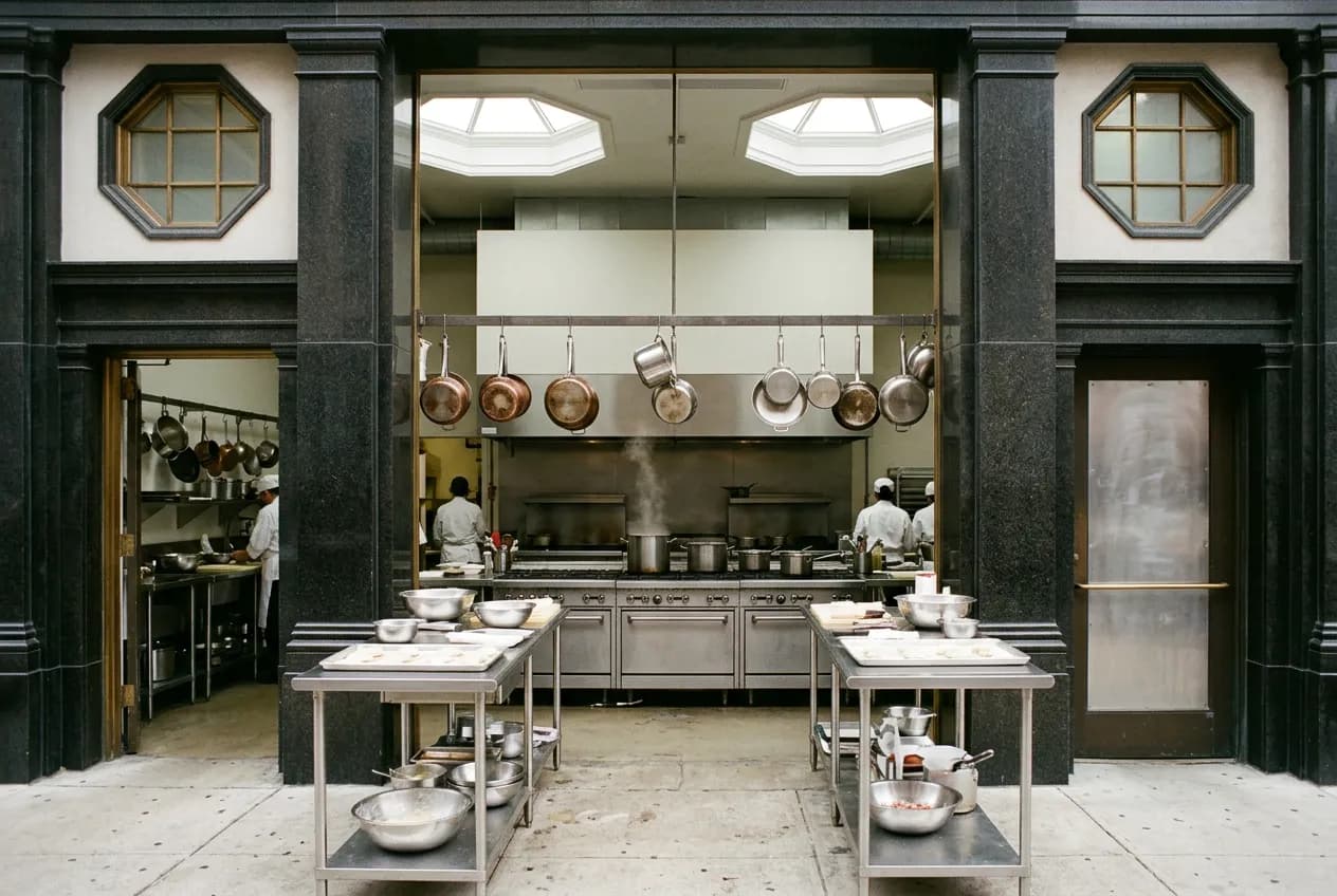 Stainless steel teaching kitchen counters with baking equipment inside a culinary school lab