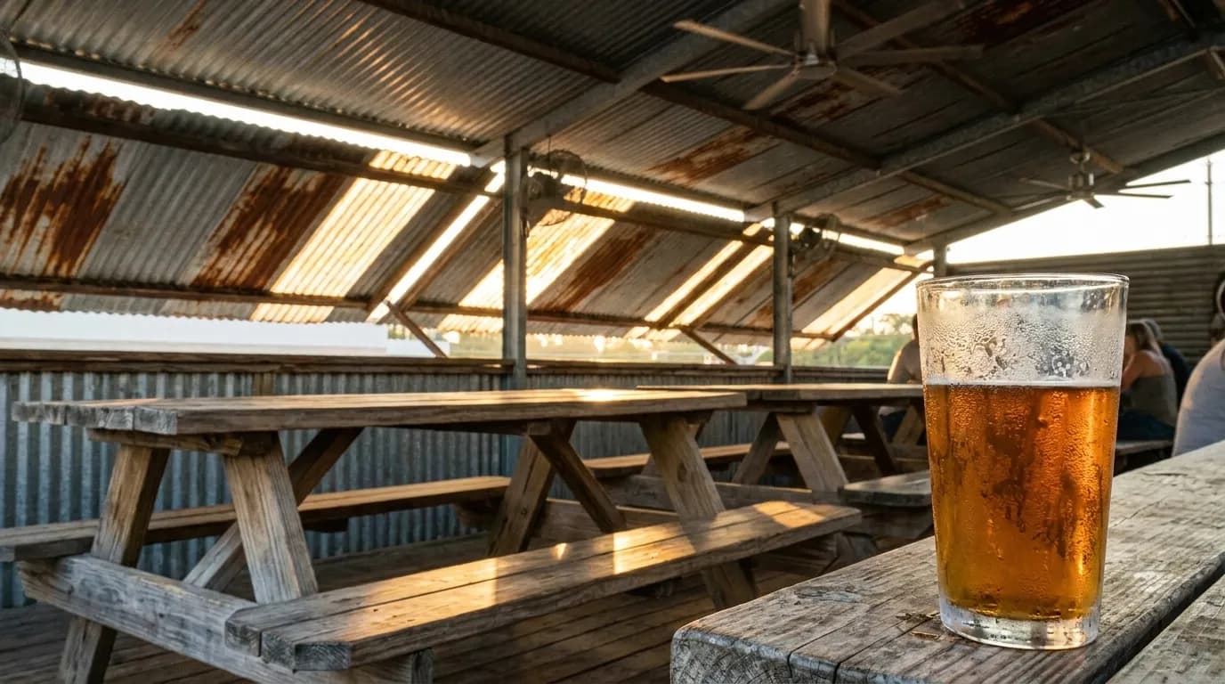 Weathered picnic tables under a metal roof at an open-air Miami bar