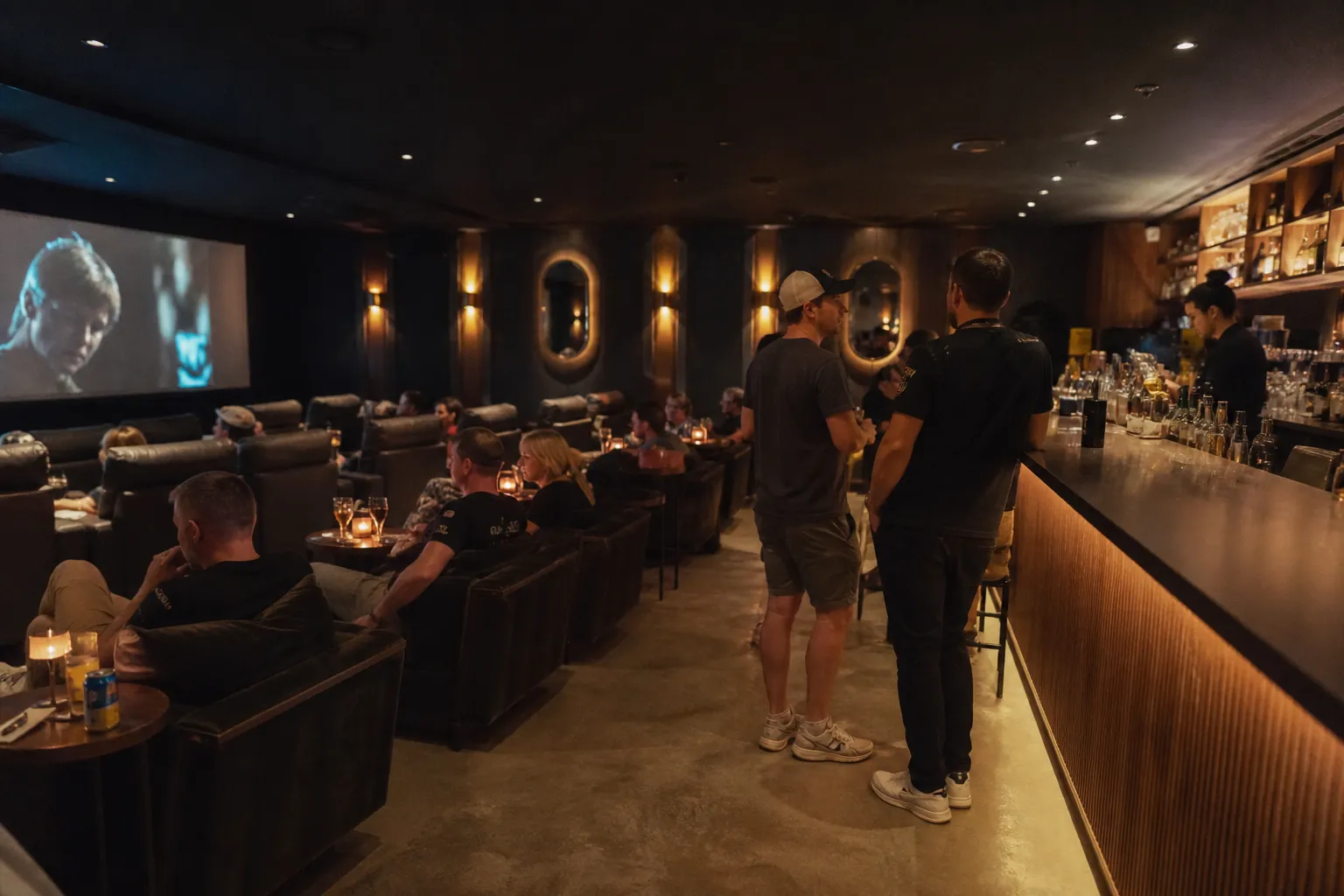 Sleek modern lounge inside a boutique movie theater with people enjoying drinks before a screening