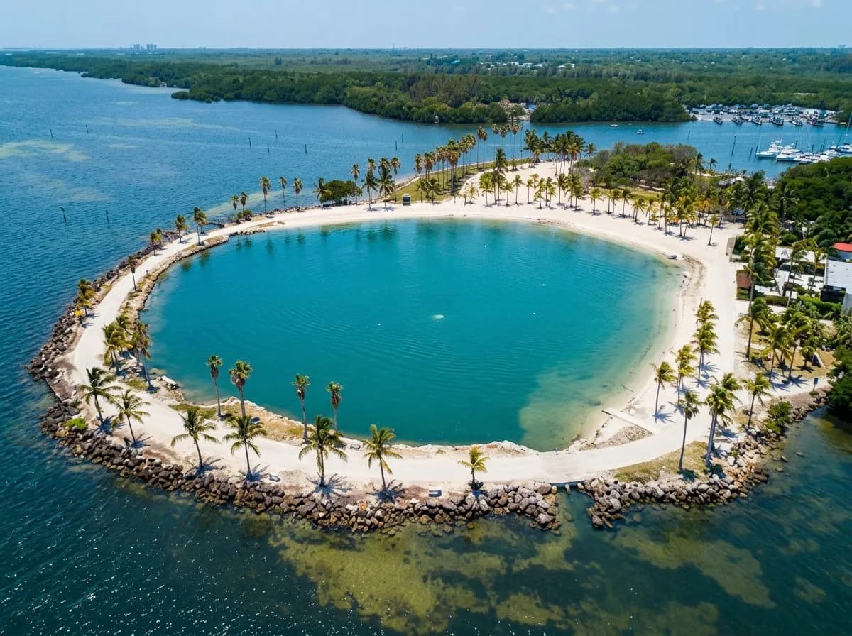 Turquoise atoll pool bordered by rock walls with mangroves and bay beyond