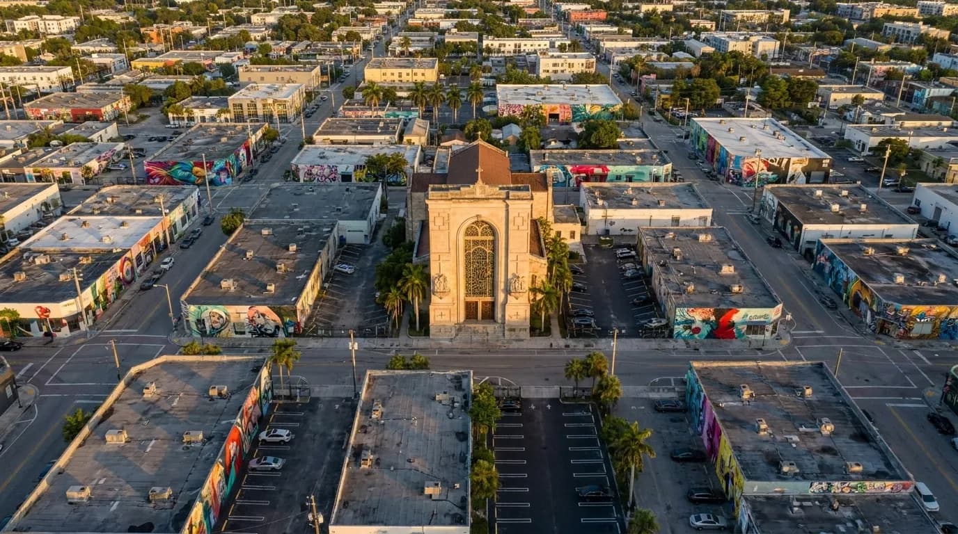 Elevated view of Wynwood neighborhood in Miami at golden hour, showing street grid and low-rise buildings with murals