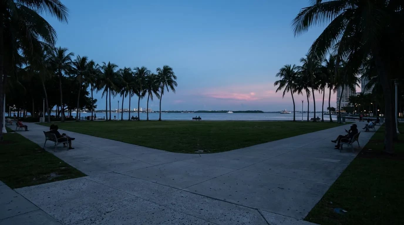 Bayfront Park at dusk with palm trees silhouetted against the Miami bay and evening sky