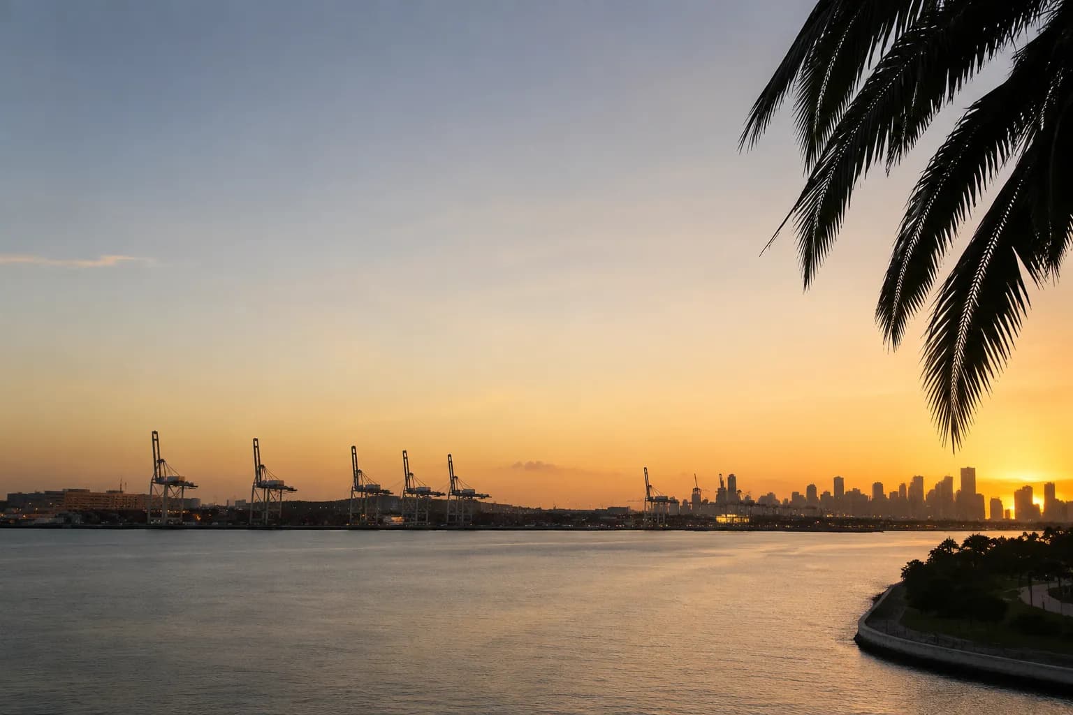 View from Pérez Art Museum terrace across Biscayne Bay at sunset with distant port skyline