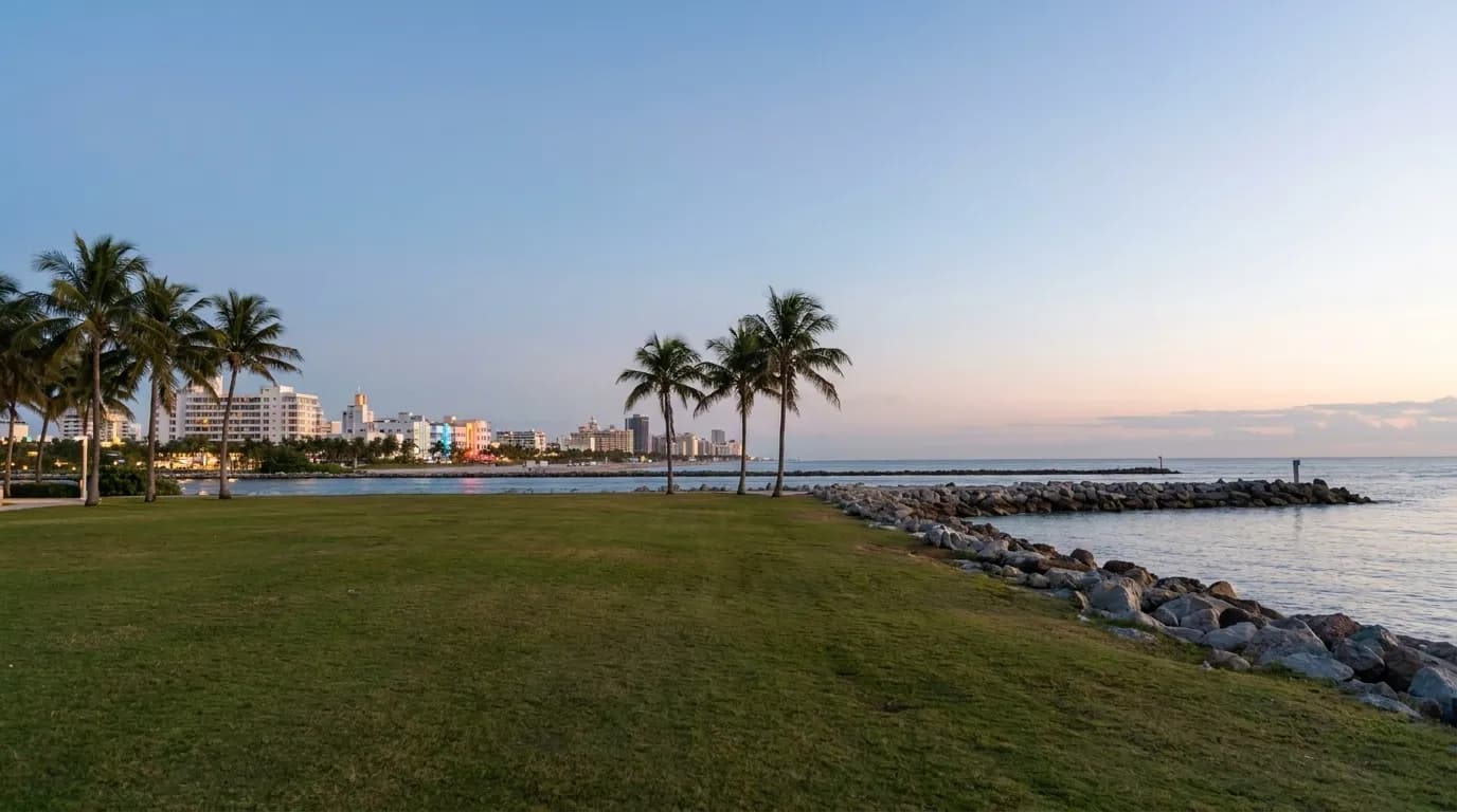 View from South Pointe Park at dusk with South Beach skyline in the distance and empty lawn in foreground