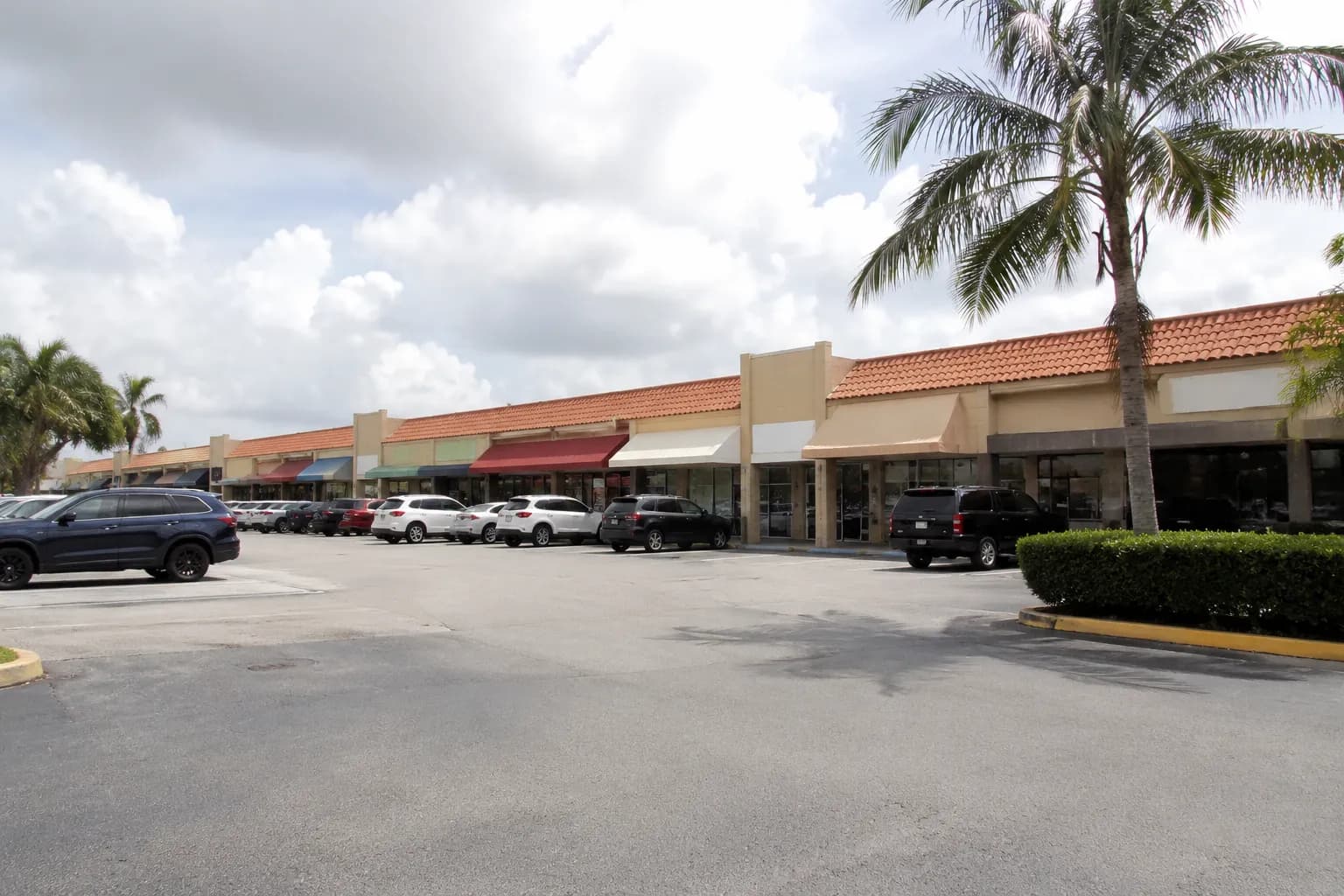 Strip mall storefronts along Bird Road in Miami on a bright afternoon