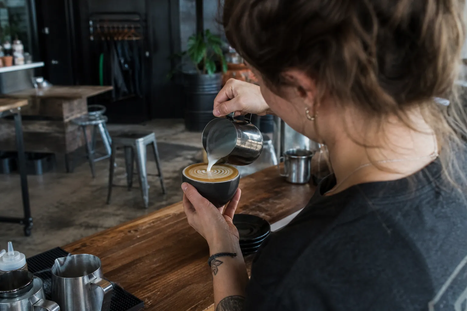 A fresh latte being prepared at the wooden counter of Panther Coffee in Miami.
