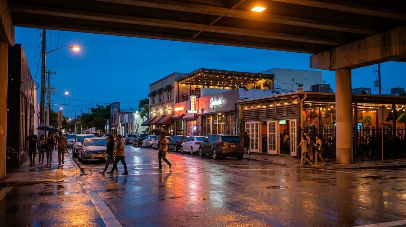 Wet asphalt on Northwest Second Avenue in Wynwood reflecting streetlights and restaurant signs at dusk