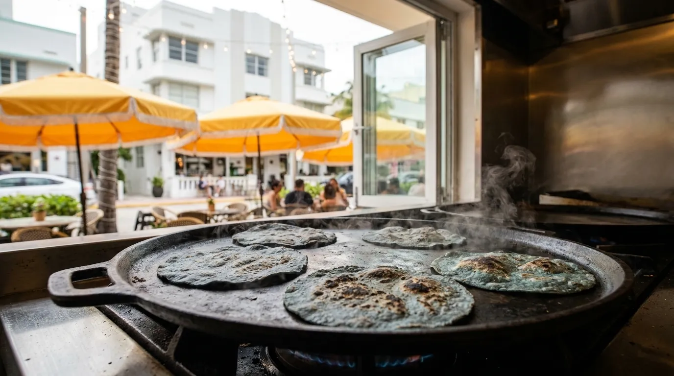 Handmade blue corn tortillas on a traditional comal with visible texture and char marks