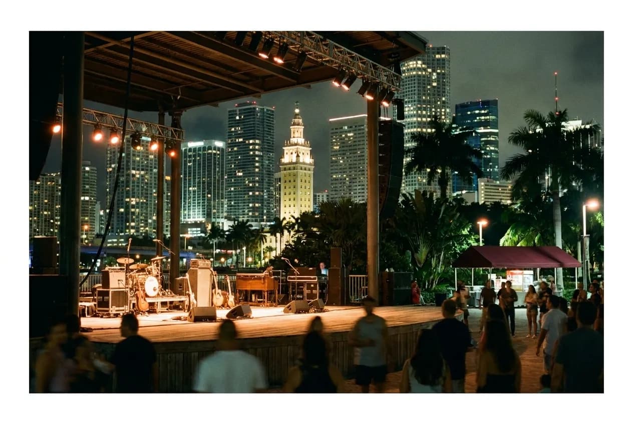 An open-air stage lit against a downtown skyline at night