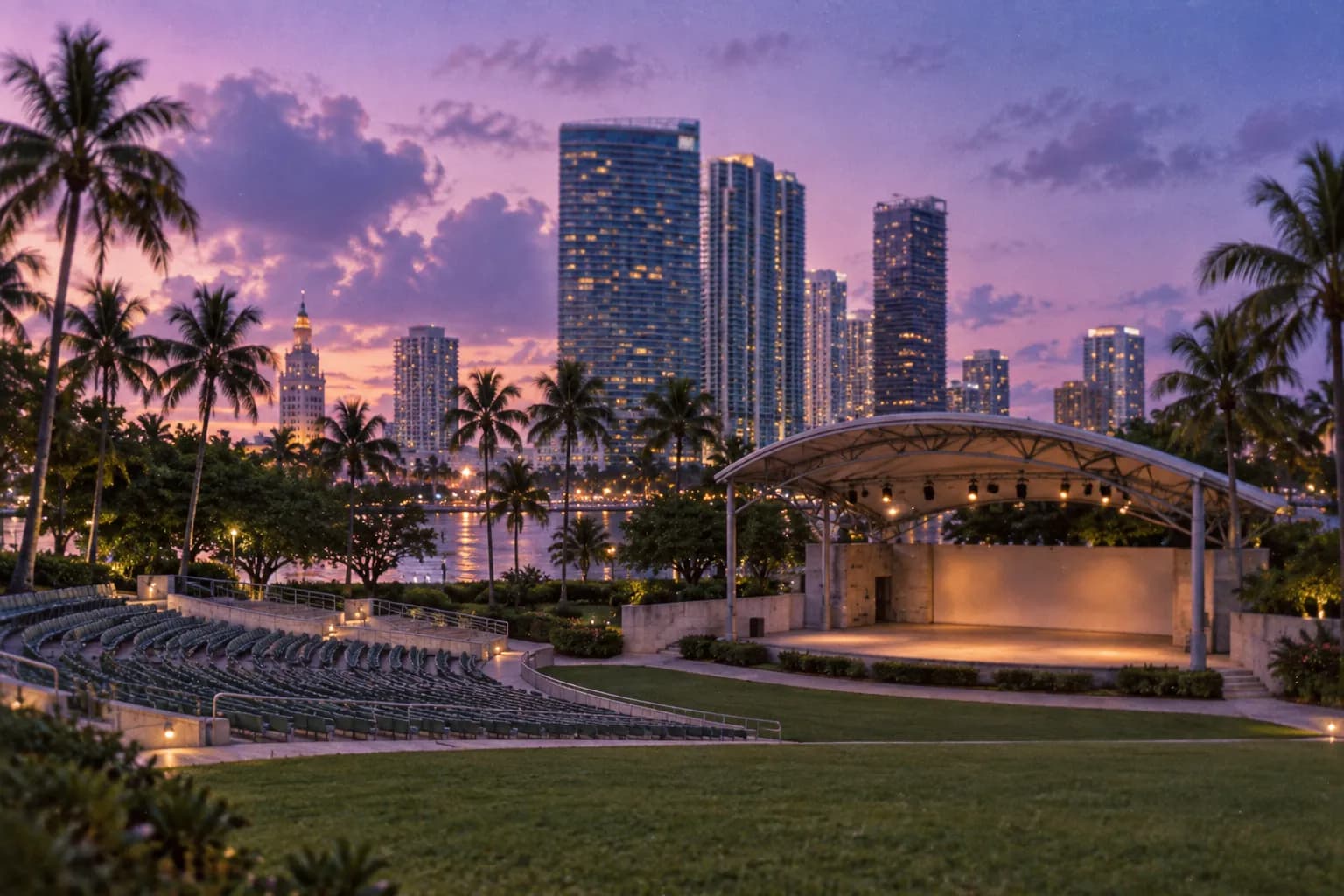 An open-air amphitheatre beside a bay with city towers behind