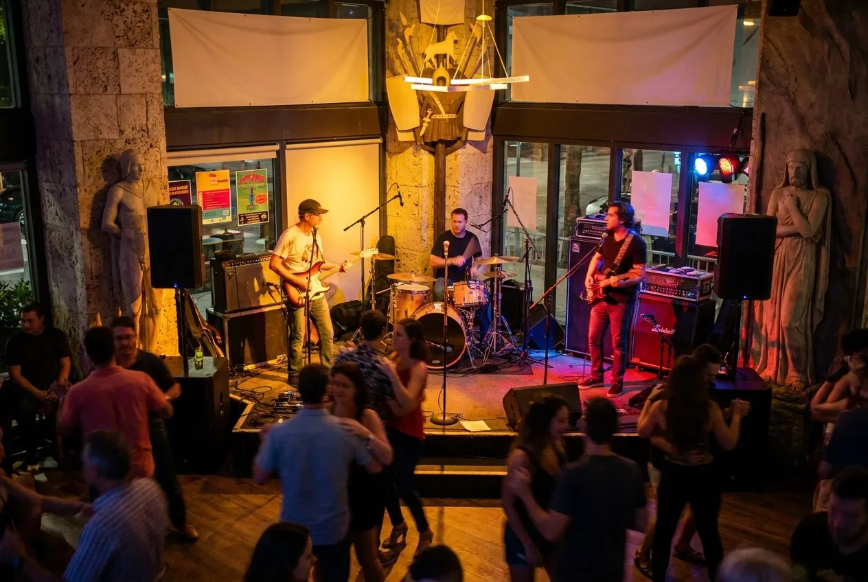 A band on a small stage with the floor in front of them already busy