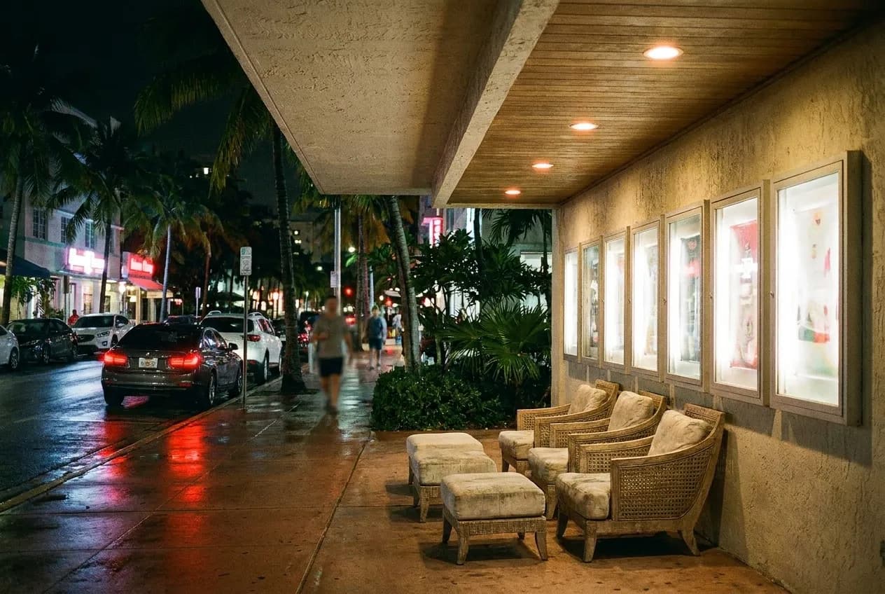 Miami street at night with lit signage and parked cars