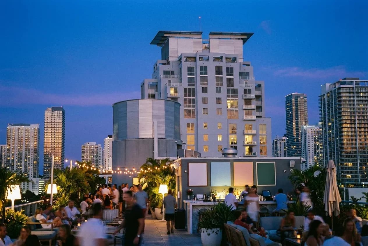 A rooftop terrace at the blue hour with the skyline standing up behind it
