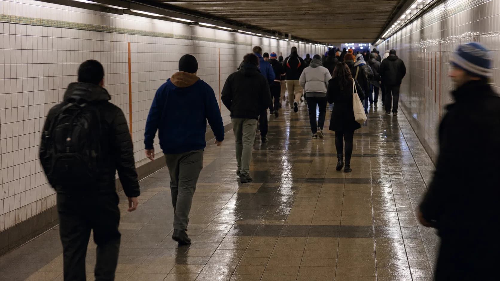 New York commuters and basketball fans walking near Penn Station on a game night.