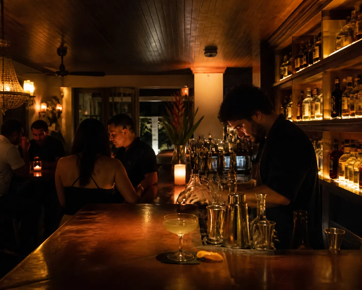 Small moody cocktail bar counter with glassware and dim lighting in Miami